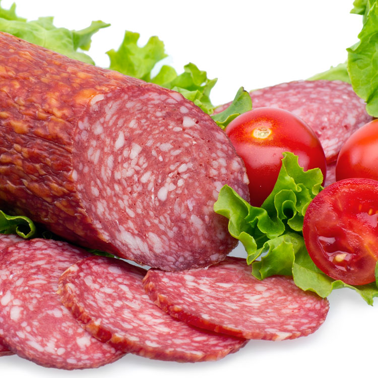 Tasty red sliced salami decorated with vegetables